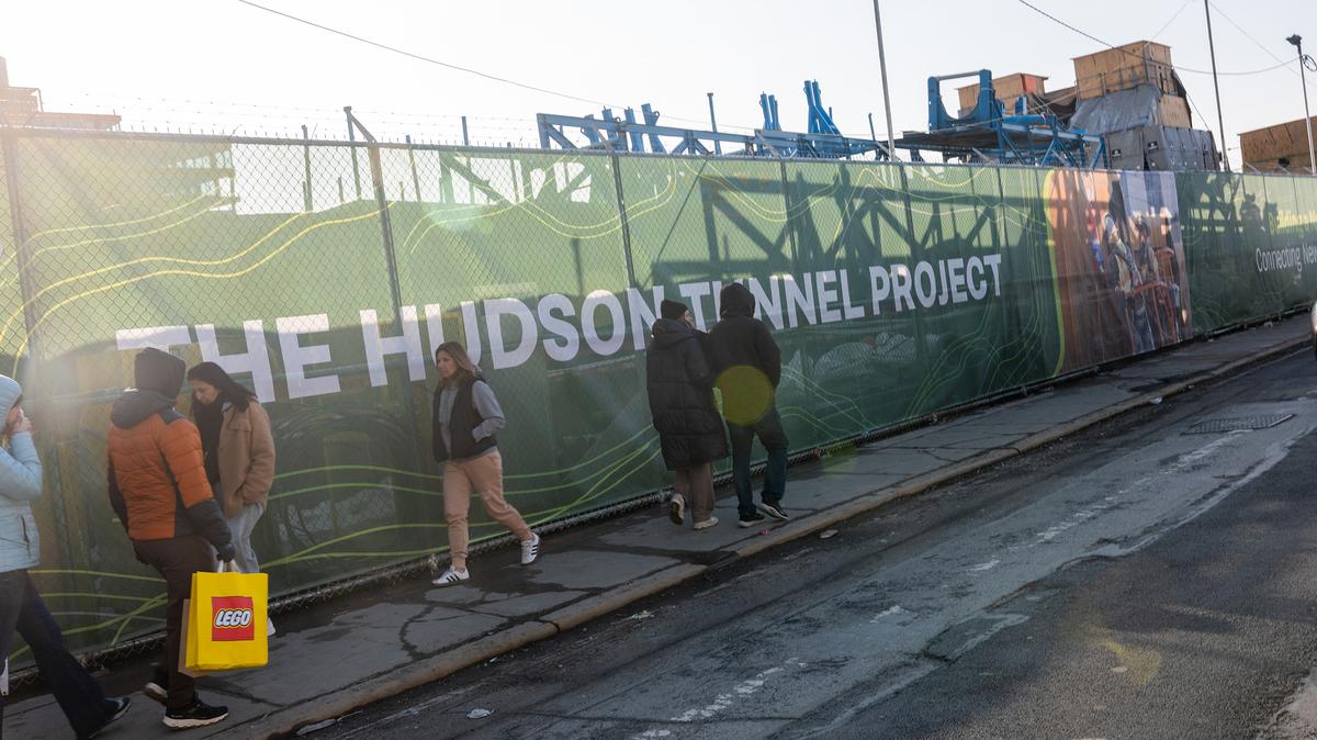 People walk past a worksite for the Gateway Hudson Tunnel on Feb. 16, 2026, in New York City. A court order released millions of dollars in federal funding that the Trump administration had frozen for the construction project last year. While construction will be able to resume, millions more in funding remain in dispute. The project, which will build a new set of rail tunnels beneath the Hudson River, is one of the largest infrastructure sites in the country and employs about 1,000 union workers. An estimated 200,000 commuters depend on NJ Transit and Amtrak trains that travel between Manhattan and New Jersey through the current Hudson River tunnels daily. (Spencer Platt/Getty Images/TNS)