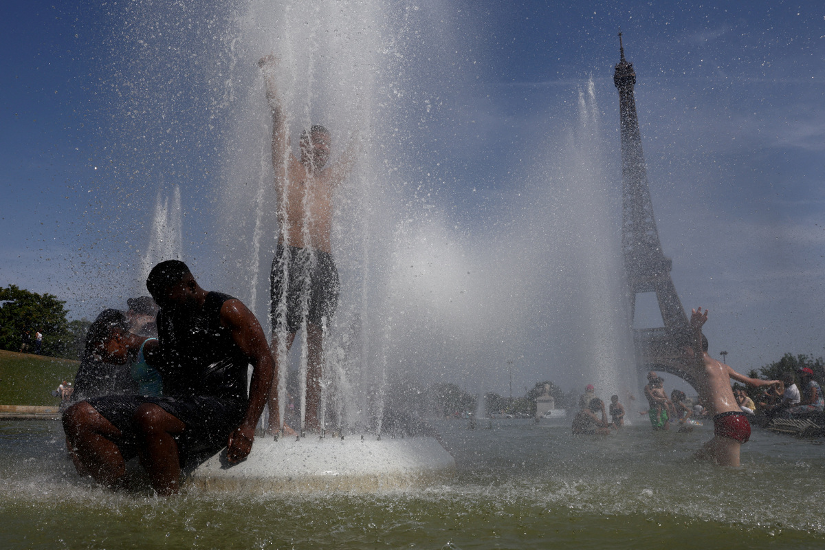 People cool off in the Trocadero Fountains by the Eiffel Tower during high temperatures amid a heatwave in Paris, France, June 27, 2026. REUTERS/Tom Nicholson