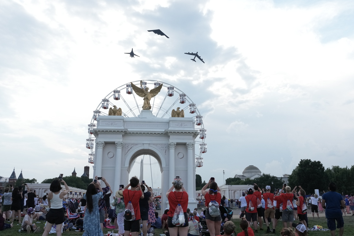 Air Force planes fly above the National Mall, and the mockup of President Donald Trump's proposed arch, on July 4, 2026. Though it was muggy and miserably hot in many parts of the country, the day was marked with the usual American exuberance, with fighter jets, tall ships, parachutists and flag-festooned pick-up trucks. (Alex Kent/The New York Times)