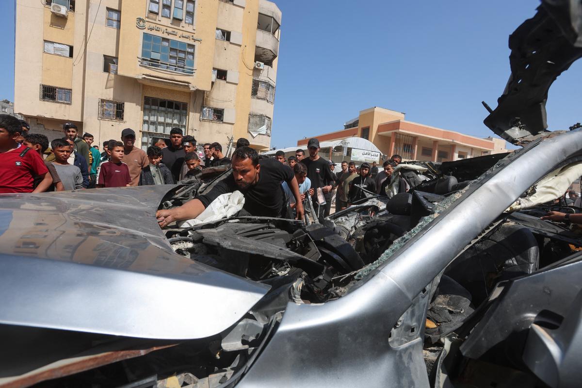 Palestinians inspect the site of an Israeli strike on a car in Khan Younis, in the southern Gaza Strip, May 10, 2026. REUTERS/Ramadan Abed