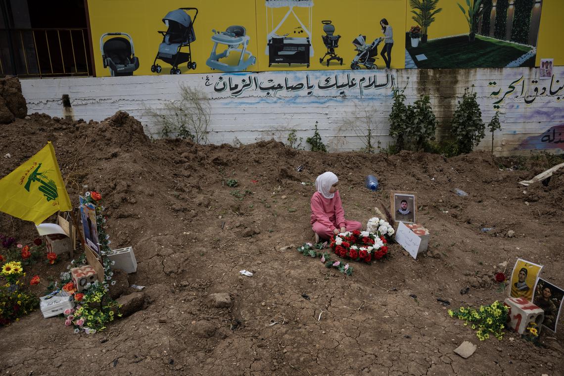 Fatima Hassan Hamzi, 9, visits a temporary grave for her uncle at a cemetery in Tyre, Lebanon, April 18, 2026. Gathering at the cemetery for the first time since the ceasefire, families hope to relocate the remains to their now accessible home villages. (David Guttenfelder/The New York Times)