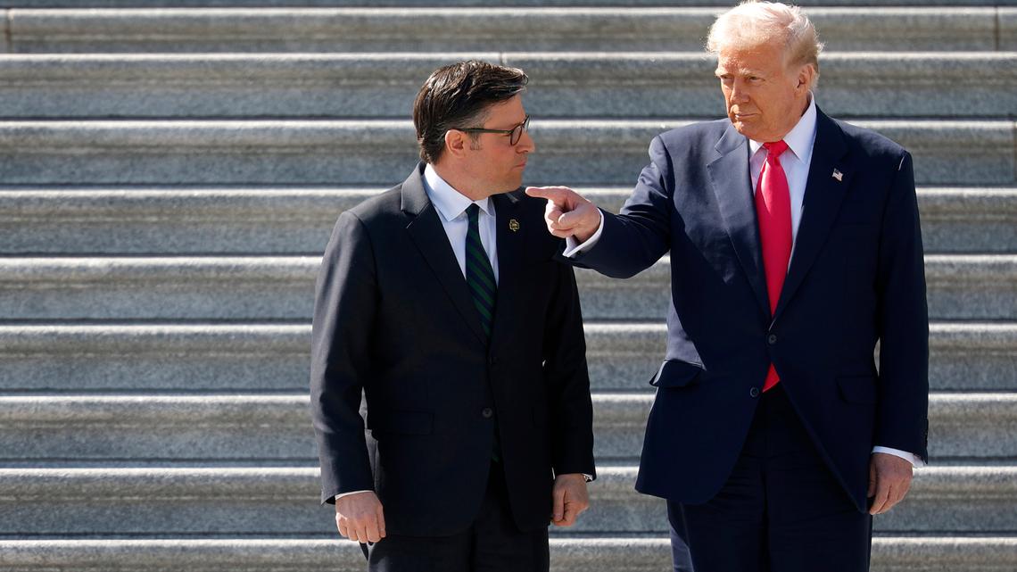 President Donald Trump speaks to House Speaker Mike Johnson (R-La.) at the U.S. Capitol in Washington on March 12.