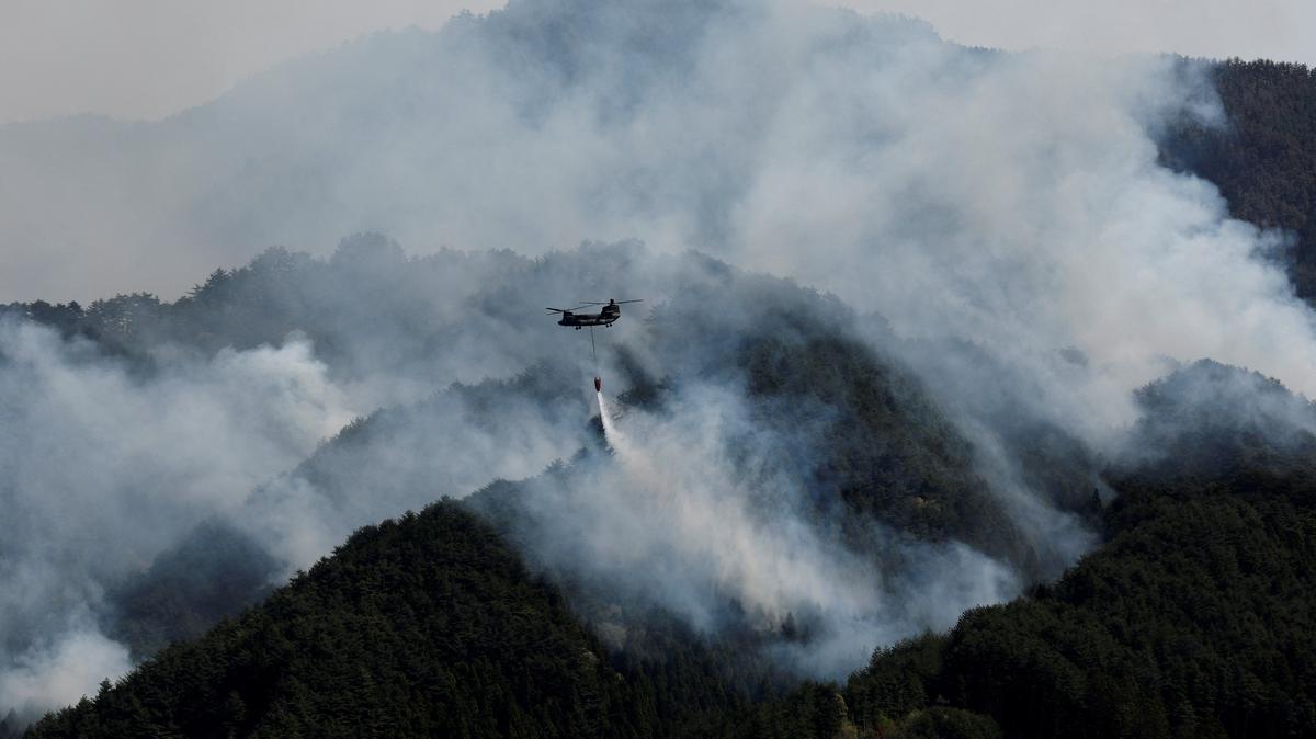FILE PHOTO: A helicopter conducts firefighting operations as wildfires continue in Otsuchi, Iwate Prefecture, Japan, April 26, 2026. REUTERS/Kim Kyung-Hoon/File Photo