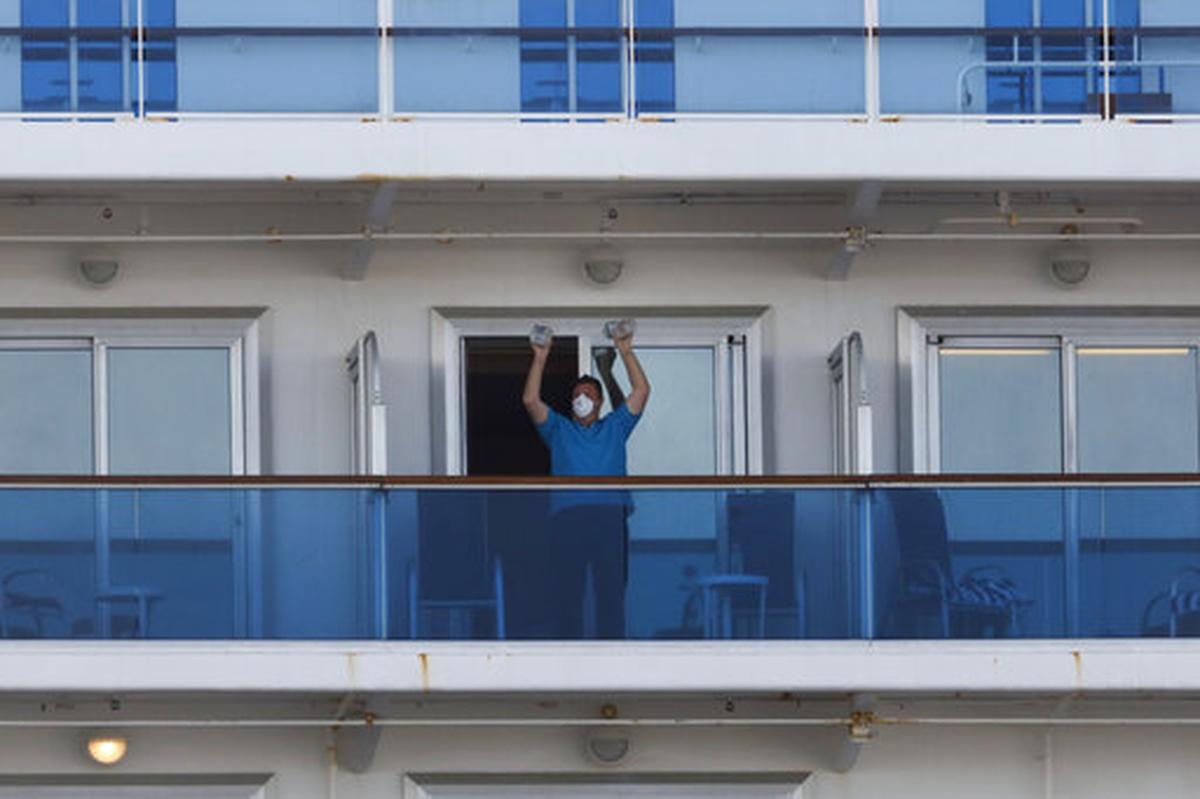 A passenger exercises using two water bottles on the quarantined Diamond Princess cruise ship.