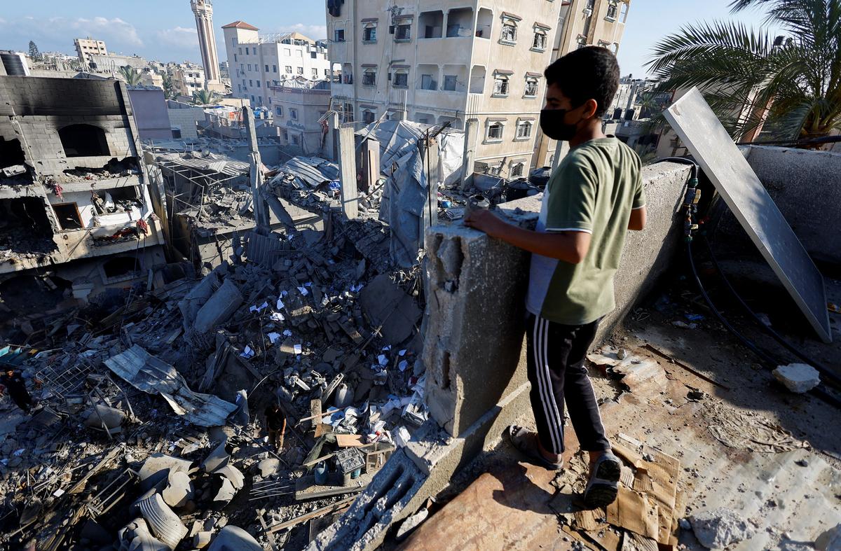 A Palestinian boy looks at the site of an Israeli strike on a house that was pre-warned by the Israeli military to evacuate before the strike was carried out late on Saturday, in Deir al-Balah, in the central Gaza Strip, May 24, 2026. REUTERS/Mahmoud Issa