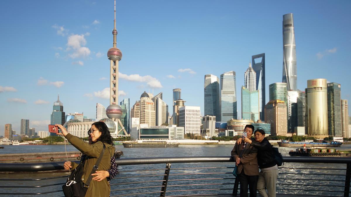 In this Nov. 12, 2020 file photo, people take selfies on the Bund in Shanghai, China.