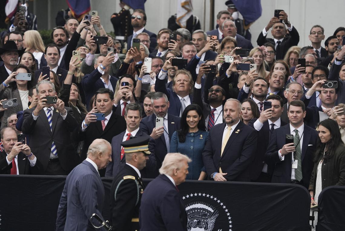 Attendees take photos and videos with their phones as President Donald Trump and King Charles III walk past during an arrival ceremony on the South Lawn of the White House in Washington, on Tuesday, April 28, 2026. (Salwan Georges/The New York Times)