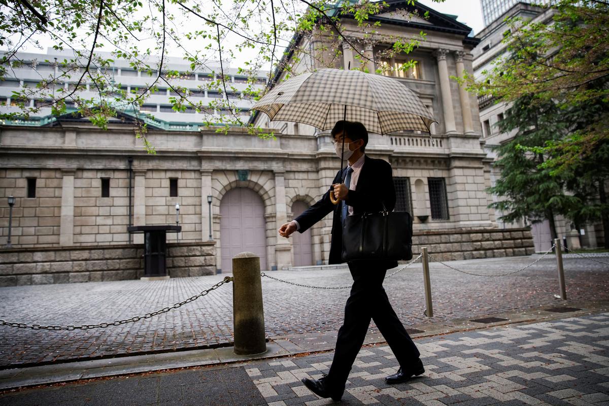 An office employee walks in front of the bank of Japan building in Tokyo, Japan, April 7, 2023. REUTERS/Androniki Christodoulou