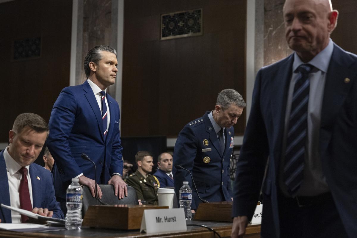 Secretary of Defense Pete Hegseth, left, and Gen. Dan Caine, chairman of the Joint Chiefs of Staff, arrive to testify during a Senate Armed Services Committee hearing on the department's budget request on Capitol Hill in Washington, on Thursday, April 30, 2026. Sen. Mark Kelly (D-Ariz.) walks past at right. (Anna Rose Layden/The New York Times)