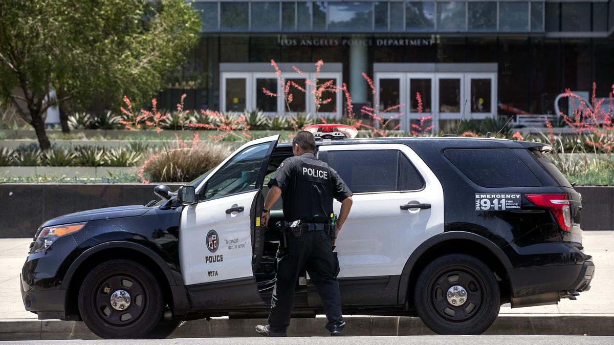 A member of the Los Angeles Police Department gets into his patrol car parked in front of police headquarters on 1st Street in downtown Los Angeles, June 21, 2021. (Mel Melcon/Los Angeles Times/TNS)