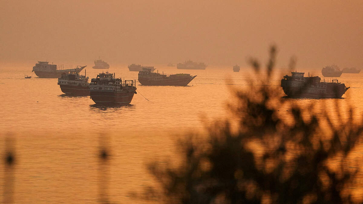 Vessels sit in the Strait of Hormuz, as seen from Musandam, Oman, on Tuesday. Both the U.S. and Iran say the strait, which normally carries about one-fifth of the world’s trade in oil and liquefied natural gas, will be open from Friday, but shipping companies say they will wait to see if peace holds.