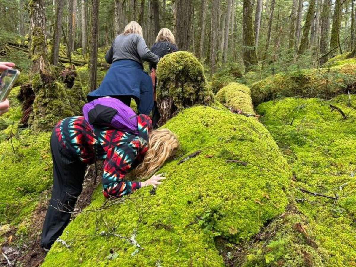  Megan presses her face into the damp moss for a natural facial during a hike. Photo credit: Mimi Slawoff 