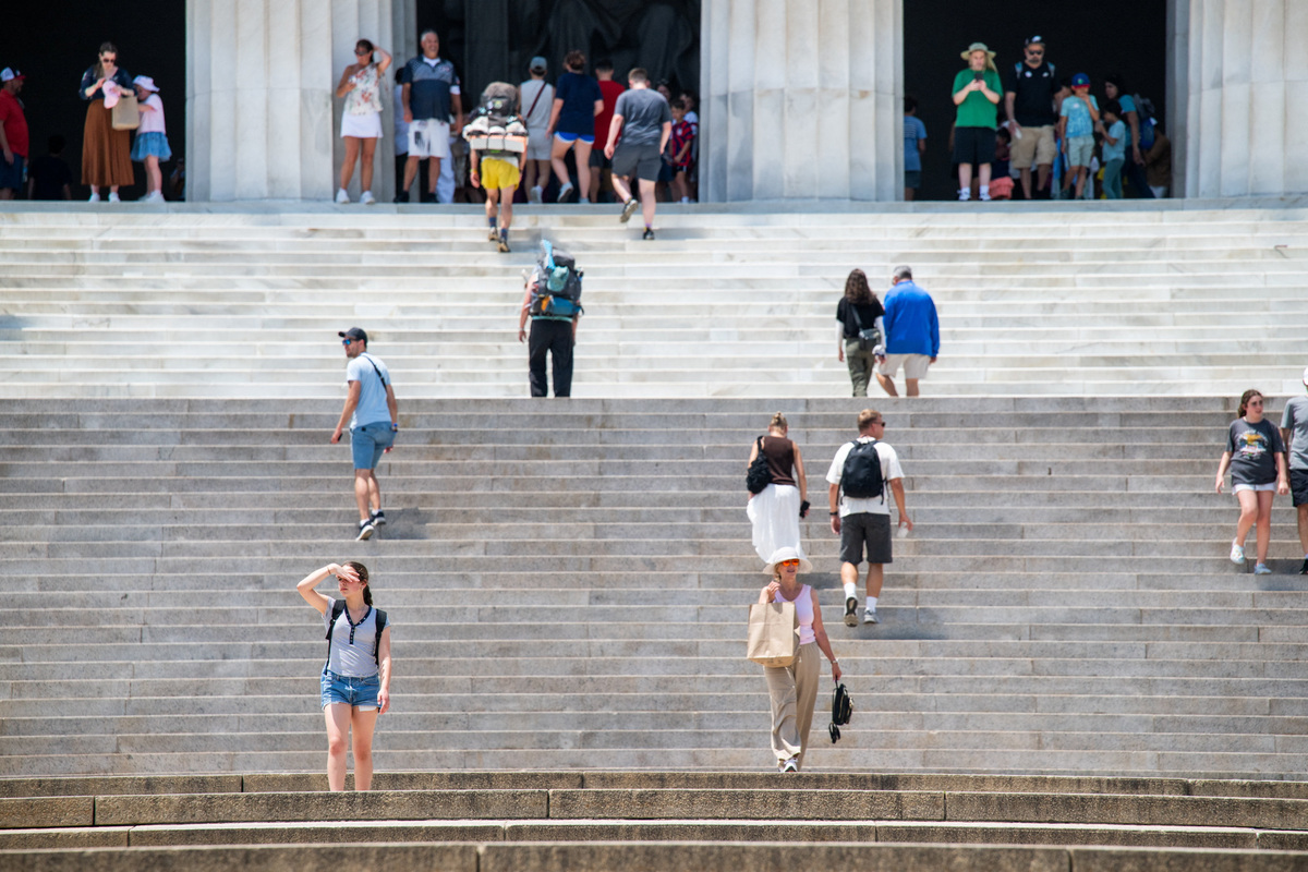 A person descending the stairs of the Lincoln Memorial covers her face with her hand amid a heatwave in Washington, D.C., U.S., July 1, 2026. REUTERS/Annabelle Gordon
