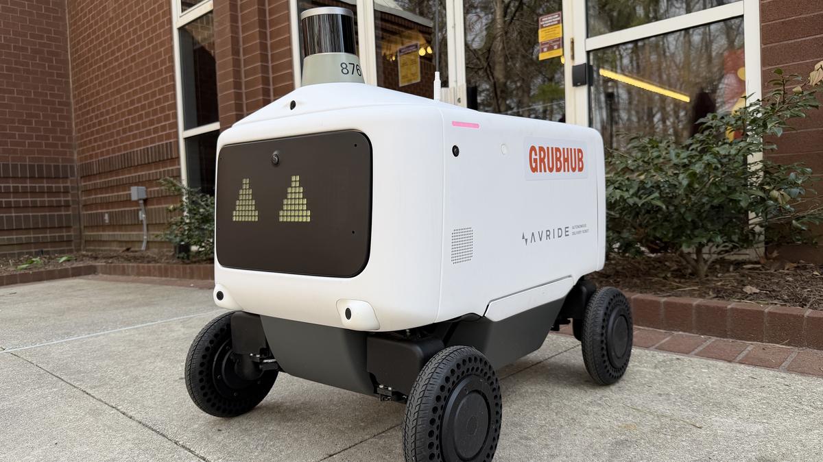 A Salisbury University food-delivery robot powers on outside a campus dining hall before beginning a delivery run. (Josh Davis/The Baltimore Sun/TNS)