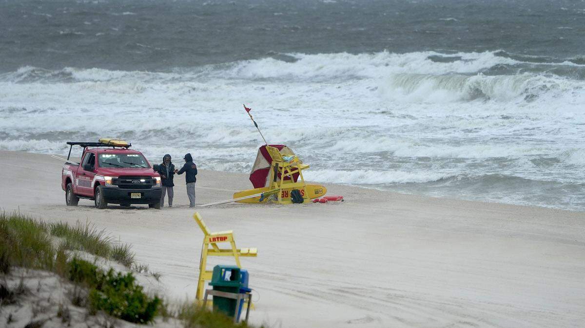Lifeguards gather near East Goodrich Avenue in Long Beach Township, New Jersey, as waves kicked up by Hurricane Erin crash into the coastline on Monday. The Eastern U.S. coastline can expect high waves, dangerous rip currents, heavy rain and strong winds as the Category 3 storm brushes by this week.