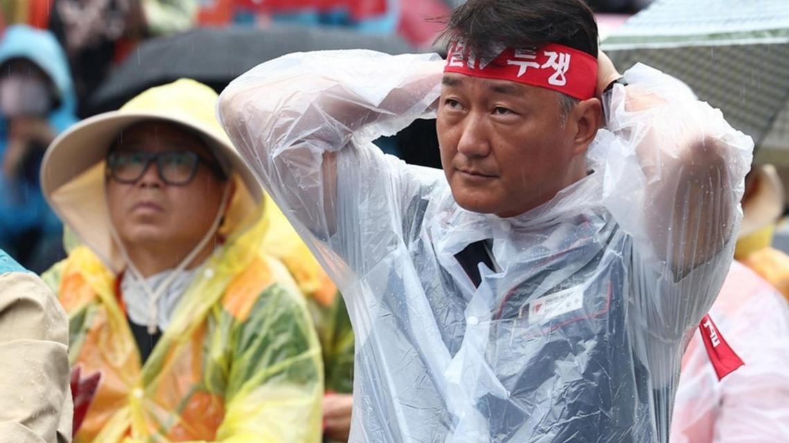 Yang Kyung-soo (R), leader of the Korean Confederation of Trade Unions (KCTU), ties a headband that reads 'Solidarity and Fight' during a rally near the National Assembly in Seoul, South Korea. File. Photo by YONHAP / EPA
