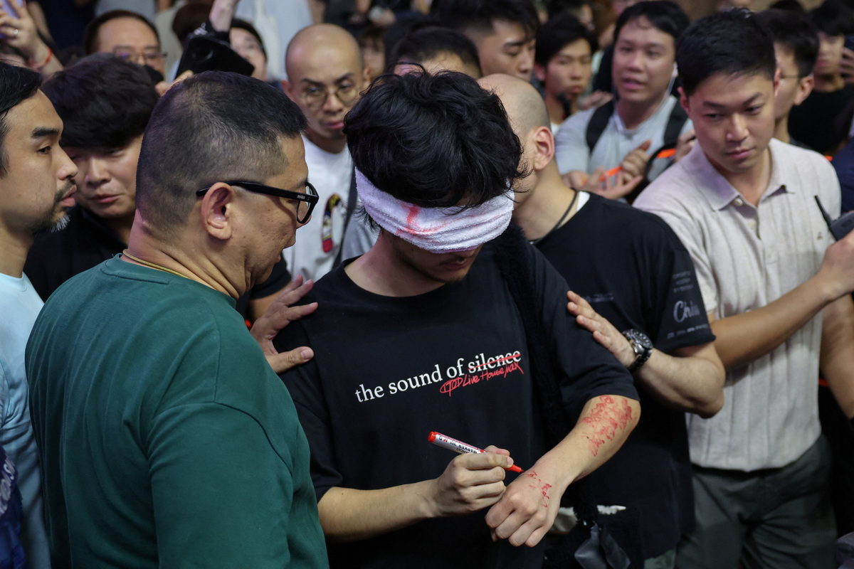 Plainclothes police detain a man holding a candle near Victoria Park, the historic site of Tiananmen Square vigils, in Hong Kong, China, June 4, 2026. REUTERS/Tyrone Siu