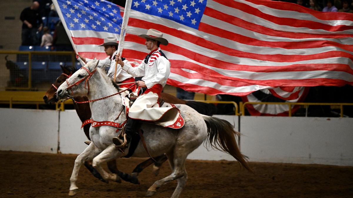 Cowboys bring in large American flags as they perform in the Wild West Show in the CINCH arena at the National Western Stock Show in Denver on Jan. 14, 2024. The show, designed to both educate and entertain, takes event-goers on a historical trip back to the days of the Old West. (Helen H. Richardson/The Denver Post/TNS)
