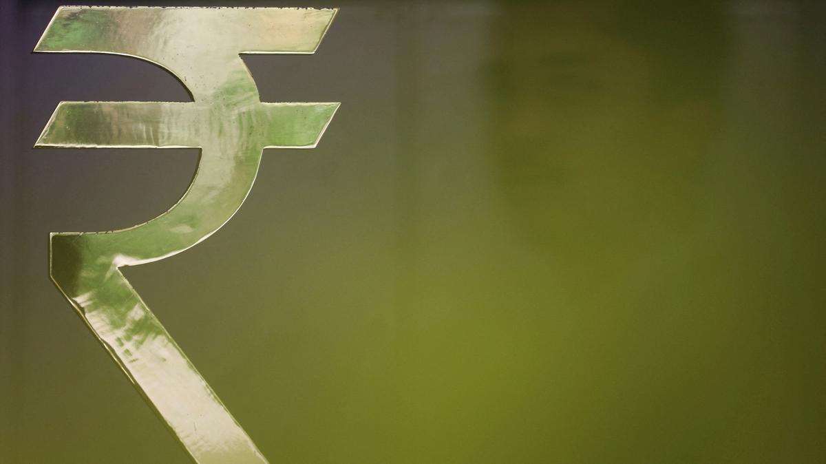 FILE PHOTO: A man walks past a Rupee installation at the Reserve Bank Of India (RBI) headquarters in Mumbai, India, April 8, 2026. REUTERS/Francis Mascarenhas/File Photo