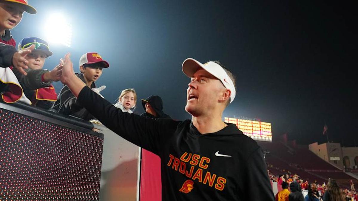  Nov 29, 2025; Los Angeles, California, USA; Southern California Trojans head coach Lincoln Riley celebrates with fans after the game against the UCLA Bruins at United Airlines Field at Los Angeles Memorial Coliseum. Mandatory Credit: Kirby Lee-Imagn Images | Kirby Lee-Imagn Images 