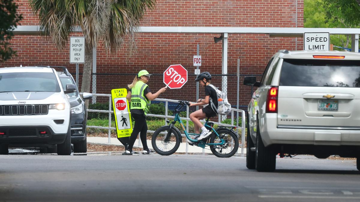 A Maitland Middle School student rides an e-bike off campus during dismissal,   Monday, April 20, 2026. Orange County Public Schools and local municipalities are considering new regulations as the popularity of electric-powered bicycles and scooters proliferates among young riders. (Joe Burbank/Orlando Sentinel)