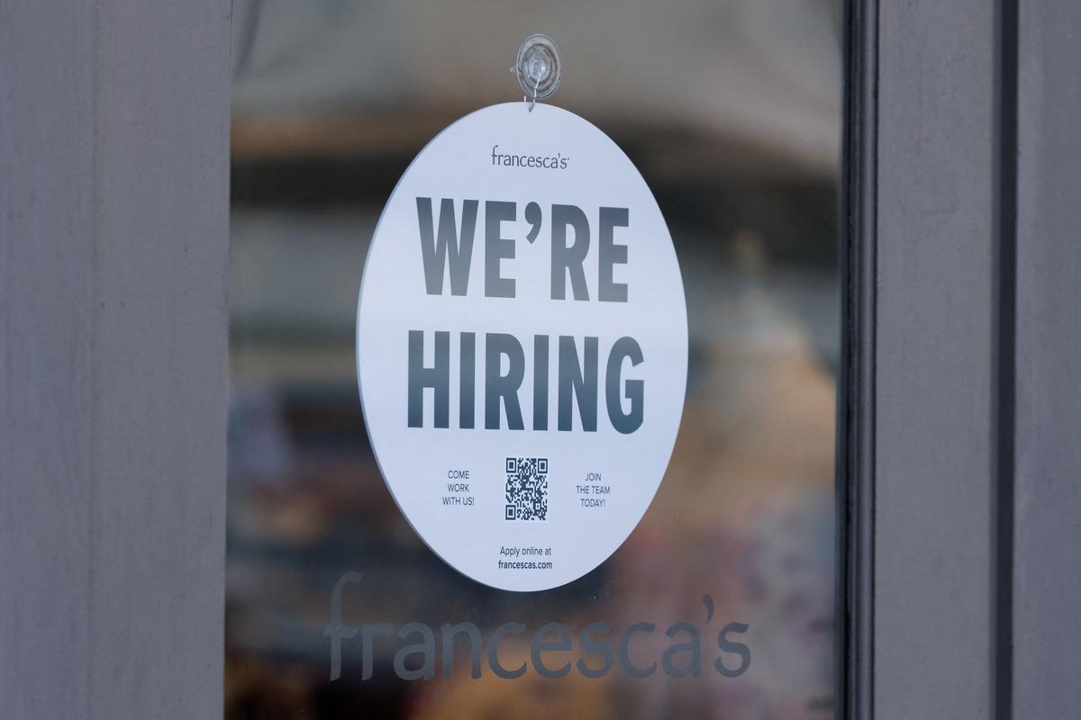 A "we're hiring" sign is displayed on the door of a local business, after U.S. employment growth slowed more than expected in July, in Encinitas, California, U.S. August 1, 2025.   REUTERS/Mike Blake