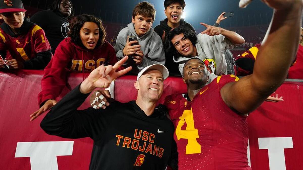  Nov 29, 2025; Los Angeles, California, USA; Southern California Trojans head coach Lincoln Riley (right) and defensive tackle Jahkeem Stewart (4) pose with fans after the game against the UCLA Bruins at United Airlines Field at Los Angeles Memorial Coliseum. Mandatory Credit: Kirby Lee-Imagn Images | IMAGN IMAGES via Reuters Connect 