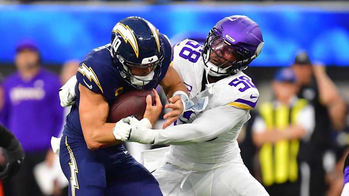  Oct 23, 2025; Inglewood, California, USA; Los Angeles Chargers quarterback Justin Herbert (10) ruses the ball against Minnesota Vikings linebacker Jonathan Greenard (58) during the first half at SoFi Stadium. Mandatory Credit: Gary A. Vasquez-Imagn Images | Gary A. Vasquez-Imagn Images 