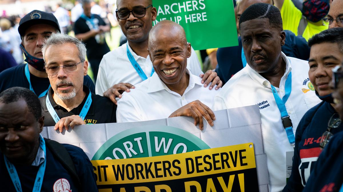 El presidente del distrito de Brooklyn y candidato demócrata a alcalde de Nueva York Eric Adams sonríe junto con participantes en un desfile en homenaje a los trabajadores esenciales en la lucha contra la pandemia de coronavirus, en Manhattanm Nueva York, el miércoles, 7 de julio del 2021. (AP Foto/John Minchillo)