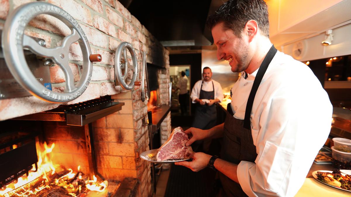 Aaron Gottesman prepares grill a 35-ounce porterhouse steak at Hearthside in Collingswood, New Jersey, on Nov. 21, 2017. Hearthside was listed on a platform selling reservations for the restaurant that is now illegal in New Jersey. (David Swanson/The Philadelphia Inquirer/TNS)