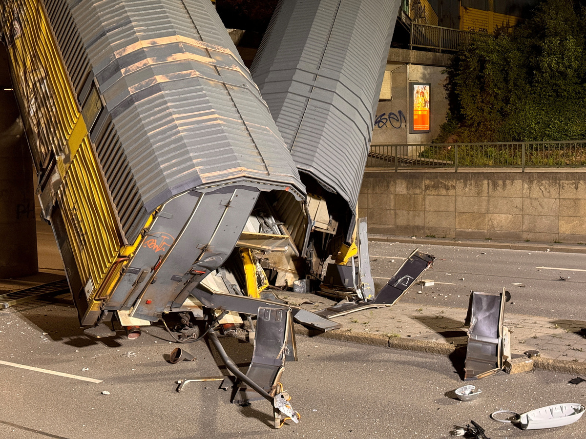 Two cars of a freight train which derailed after a collision, fell off a bridge and lay on a road in Munich, Germany, June 20, 2026.   REUTERS/Christine Uyanik