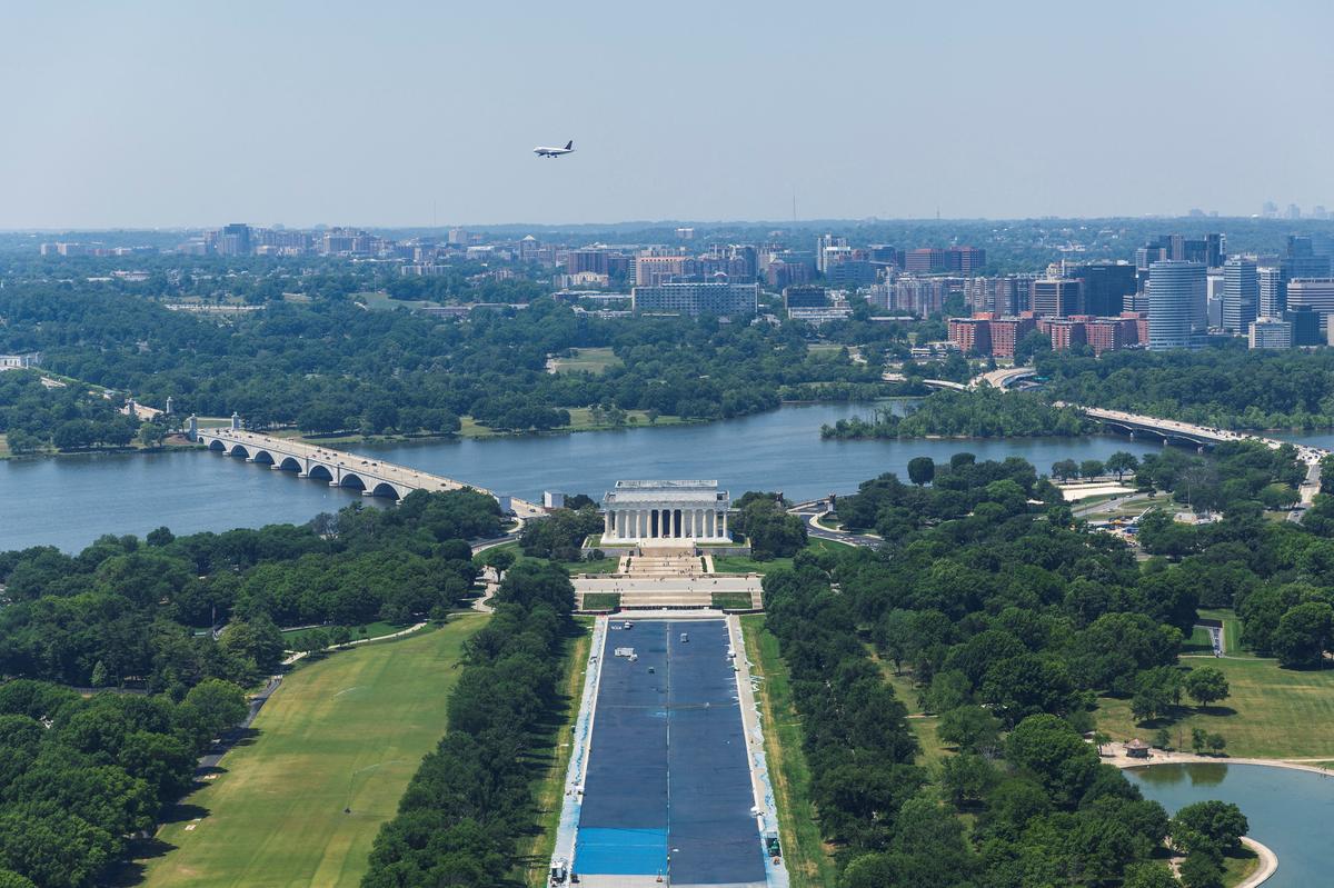 FILE PHOTO: A commercial aircraft flies above, as workers paint the Lincoln Memorial Reflecting Pool blue at the directive of U.S. President Donald Trump on the National Mall in Washington, D.C., U.S, May 18, 2026. REUTERS/Tom Brenner/File Photo