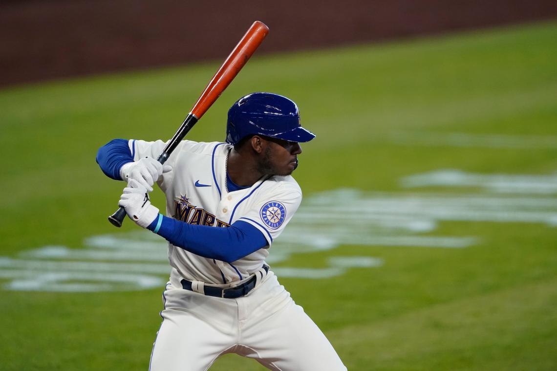 In this Aug. 23, 2020, file photo, Seattle Mariners’ Kyle Lewis begins his swing on a solo home run against the Texas Rangers during the first inning of a baseball game in Seattle. Lewis won the AL Rookie of the Year award.