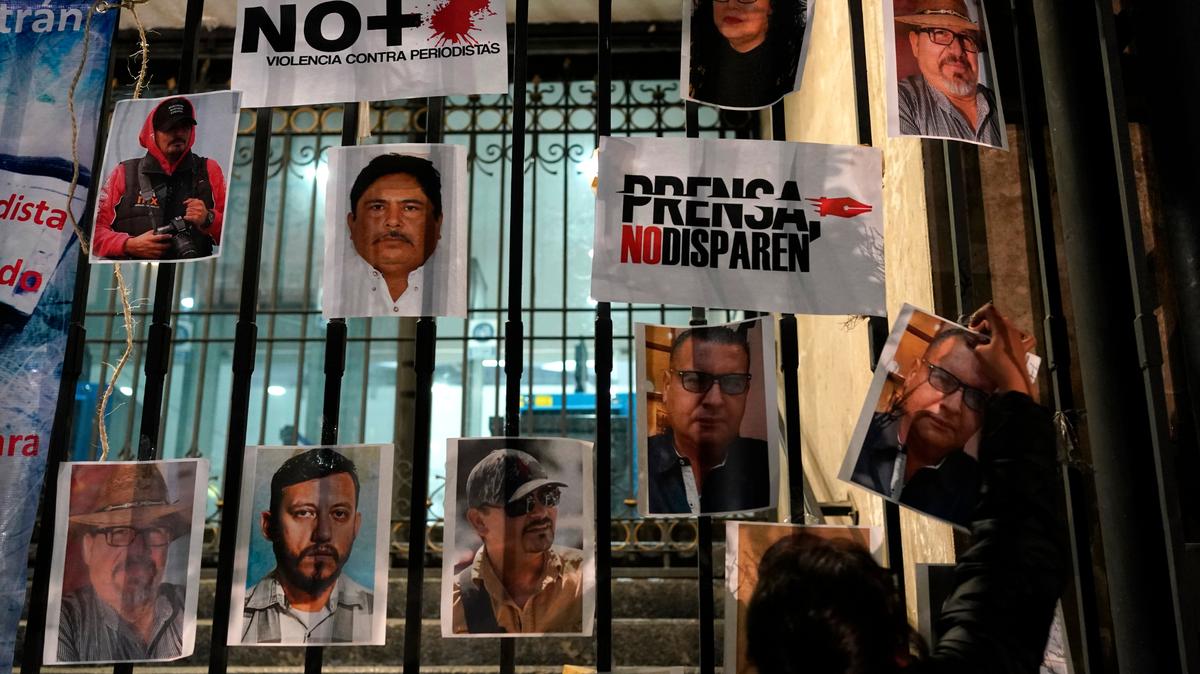 Una mujer coloca fotos de reporteros muertos durante una protesta nacional por el asesinato de Lourdes Maldonado y del fotógrafo independiente Margarito Martínez, en la Ciudad de México, el 25 de enero de 2022. El subsecretario mexicano de Interior, Alejandro Encinas, dijo recientemente que más del 90% de asesinatos de periodistas y activistas de derechos siguen sin resolver, a pesar de que el gobierno tiene un sistema que trata de protegerlos. (AP Foto/Eduardo Verdugo)