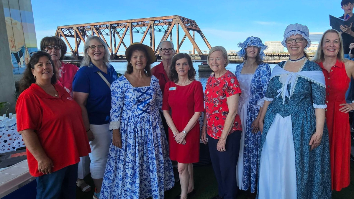 Carol Garner, front in blue and white period dress, the local Daughters of the American Revolution member who researched Cow Ford, joins other DAR members to unveil a new historical marker in Jacksonville.