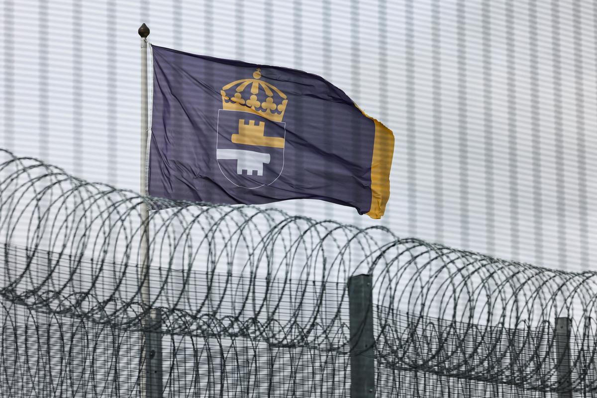 The flag of the Swedish Prison and Probation Service flutters behind the fence surrounding Rosersberg Prison near Stockholm, Sweden, May 25, 2026. REUTERS/Tom Little