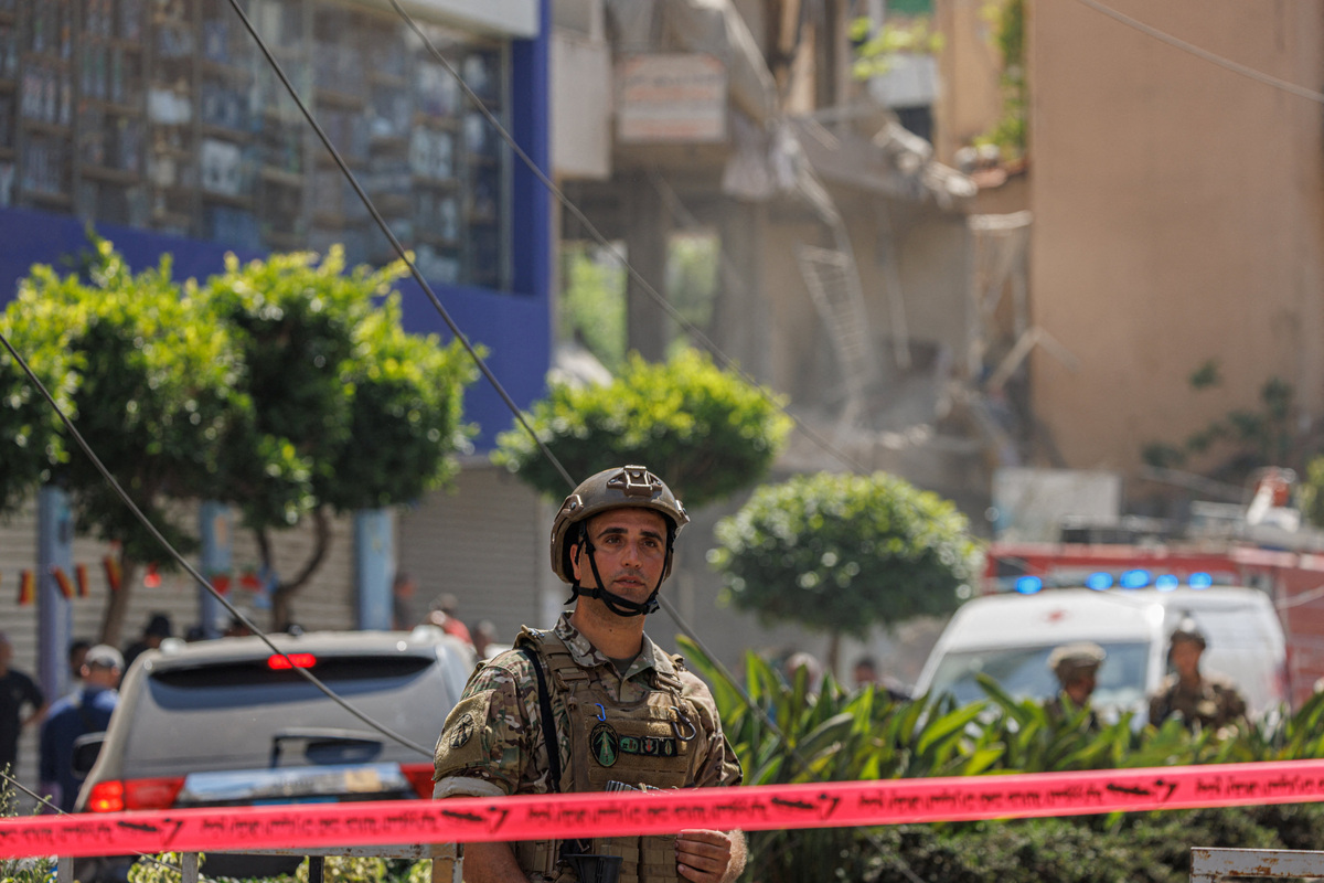 A Lebanese army officer stands as police officers and emergency personnel work at the site of an Israeli strike on the southern suburbs of Beirut, Lebanon, June 14, 2026. REUTERS/Zohra Bensemra