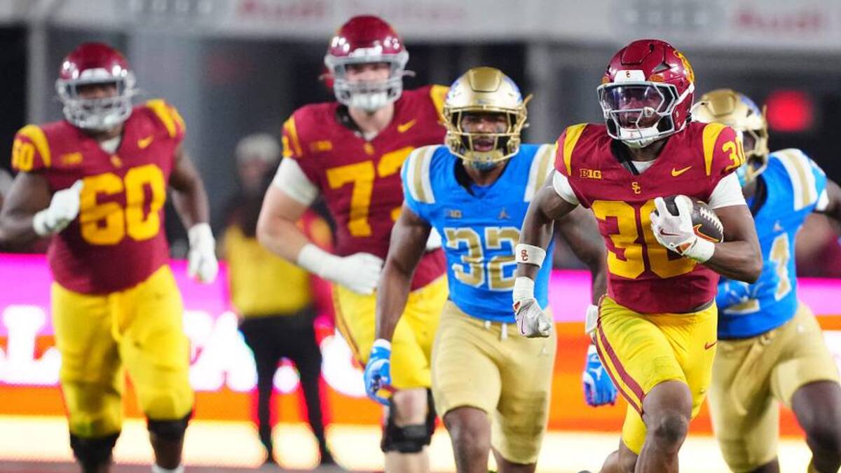  Nov 29, 2025; Los Angeles, California, USA; Southern California Trojans running back King Miller (30) carries the ball against UCLA Bruins linebacker Isaiah Chisom (32) in the first half at United Airlines Field at Los Angeles Memorial Coliseum. Mandatory Credit: Kirby Lee-Imagn Images | Kirby Lee-Imagn Images 