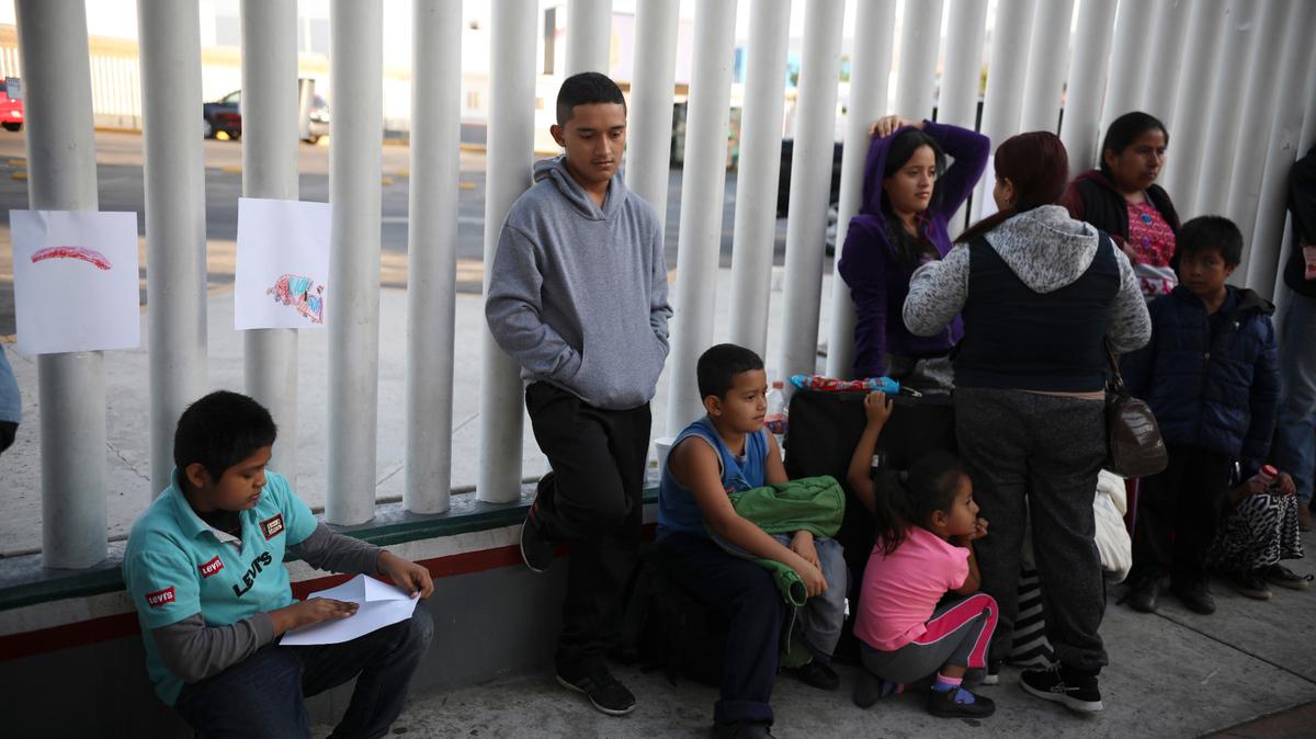 Inmigrantes centroamericanos esperan para saber si pueden cruzar la frontera y pedir asilo en Estados Unidos, en el punto fronterizo el Chaparral en Tijuana, México, el 13 de septiembre de 2019.