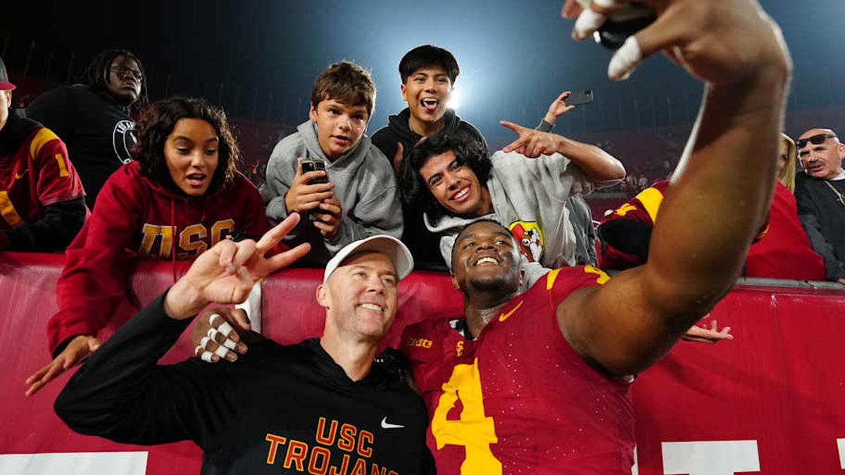  Nov 29, 2025; Los Angeles, California, USA; Southern California Trojans head coach Lincoln Riley (right) and defensive tackle Jahkeem Stewart (4) pose with fans after the game against the UCLA Bruins at United Airlines Field at Los Angeles Memorial Coliseum. Mandatory Credit: Kirby Lee-Imagn Images | Kirby Lee-Imagn Images 