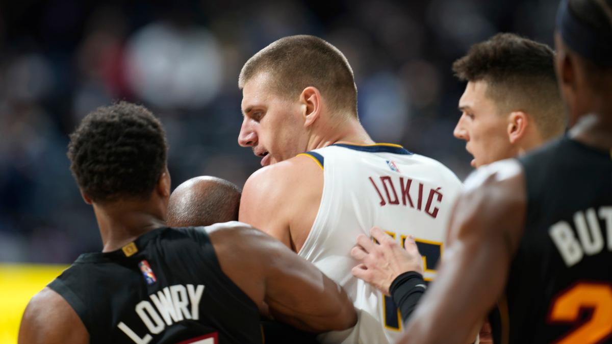 El pívot de los Nuggets de Denver, Nikola Jokic, en el centro, es restringido por los escoltas de los Miami Heat, Kyle Lowry, a la izquierda, y Tyler Herro después de derribar al alero del Heat, Markieff Morris, en la segunda mitad del partido celebrado el lunes 8 de noviembre de 2021 en Denver.