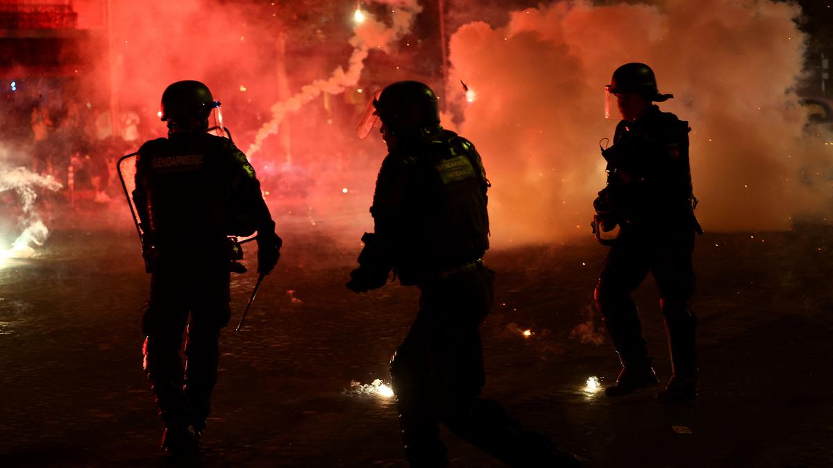 Soccer Football - UEFA Champions League -  Paris St Germain fans celebrate winning the UEFA Champions League - Paris, France - May 31, 2026 Police officers protect themselves from flares after Paris St Germain won the UEFA Champions League REUTERS/Abdul Saboor