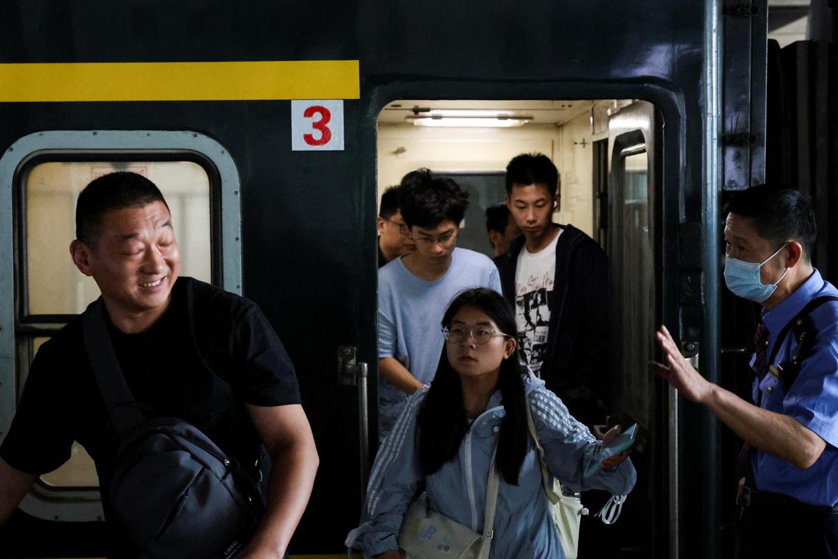 People disembark from a train after arriving at Hangzhou South Railway Station during the five-day Labour Day holiday in Hangzhou, China May 4, 2025. REUTERS/Go Nakamura