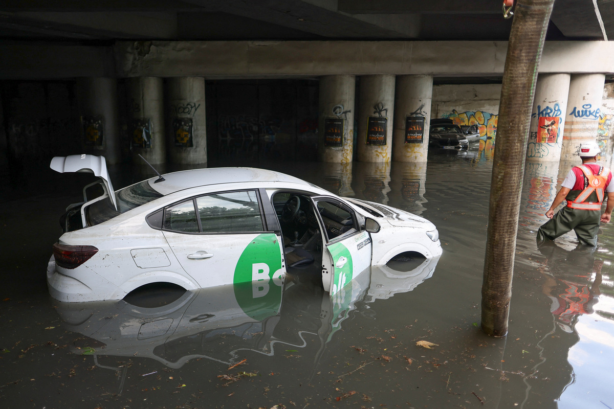 A worker watches as rainwater is pumped out of a flooded railway underpass in northern Bucharest, Romania, July 1, 2026. Inquam Photos/Octav Ganea via REUTERS
