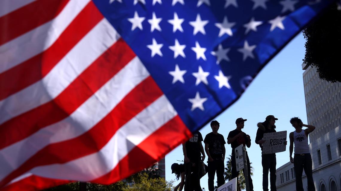 Protesters stand on top of a bus stop during an "ICE Out of Everywhere" protest in downtown Los Angeles on Jan. 30. Since last July, the Department of Homeland Security has ordered that all immigrants it arrests are subject to “mandatory detention.” But some remain imprisoned despite judicial rulings ordering them released.