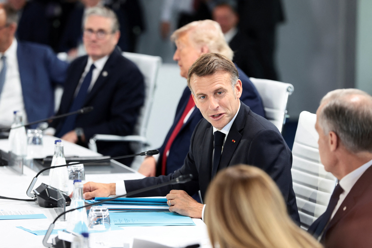 French President Emmanuel Macron speaks with Canadian Prime Minister Mark Carney and Italian Prime Minister Giorgia Meloni as they attend a working session with G7 leaders and outreach partners on promoting economic growth during the G7 Summit in Evian-les-Bains, France, June 17, 2026. REUTERS/Evelyn Hockstein