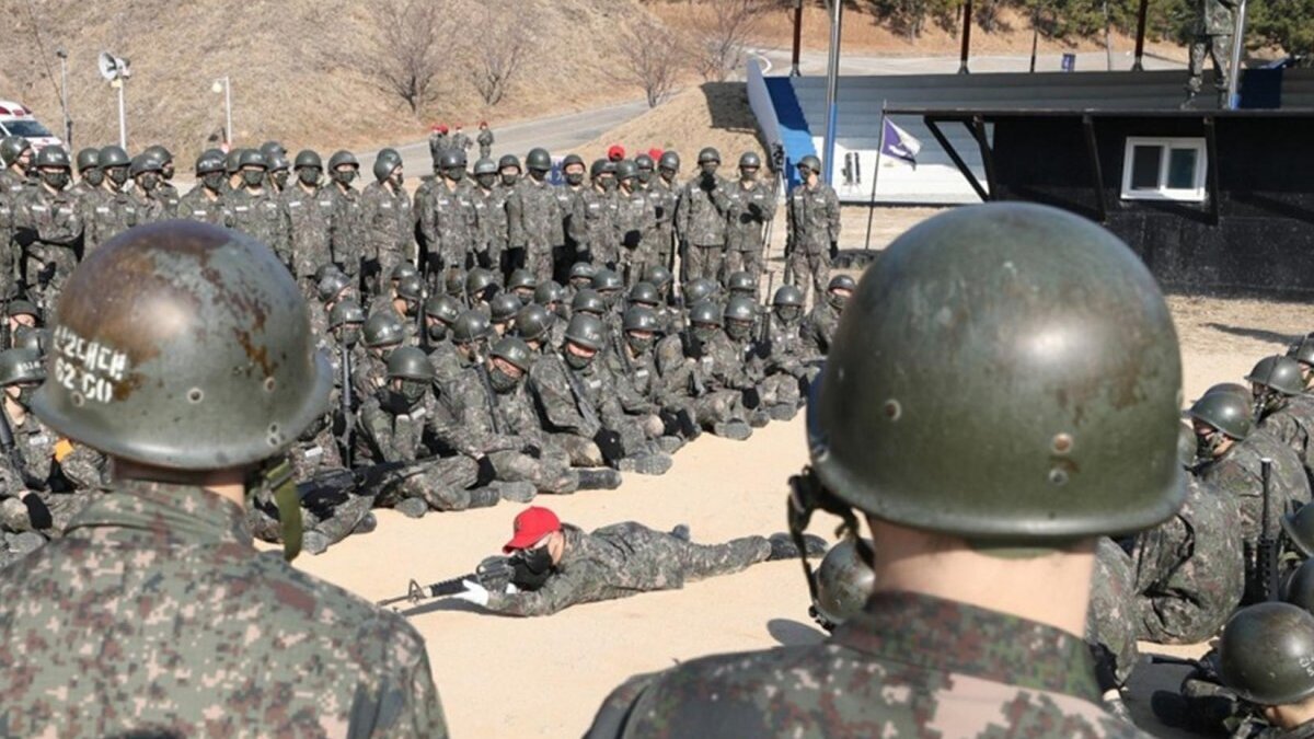 South Korean Navy conscripts are taught how to grip their rifles by an instructor (wearing a red cap) ahead of a training session to learn individual combat skills at a boot camp in the southeastern city of Changwon, South Korea. Photo by YONHAP / EPA