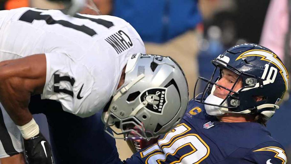  Nov 30, 2025; Inglewood, California, USA; Las Vegas Raiders safety Jeremy Chinn (11) tackles Los Angeles Chargers quarterback Justin Herbert (10) during the first half at SoFi Stadium. Mandatory Credit: Jayne Kamin-Oncea-Imagn Images | Jayne Kamin-Oncea-Imagn Images 