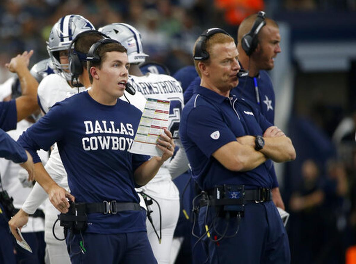 Dallas Cowboys offensive coordinator Kellen Moore, left, makes a call as head coach Jason Garrett, right, stands by in the first half of an NFL football game against the Miami Dolphins in Arlington, Texas, in 2019.