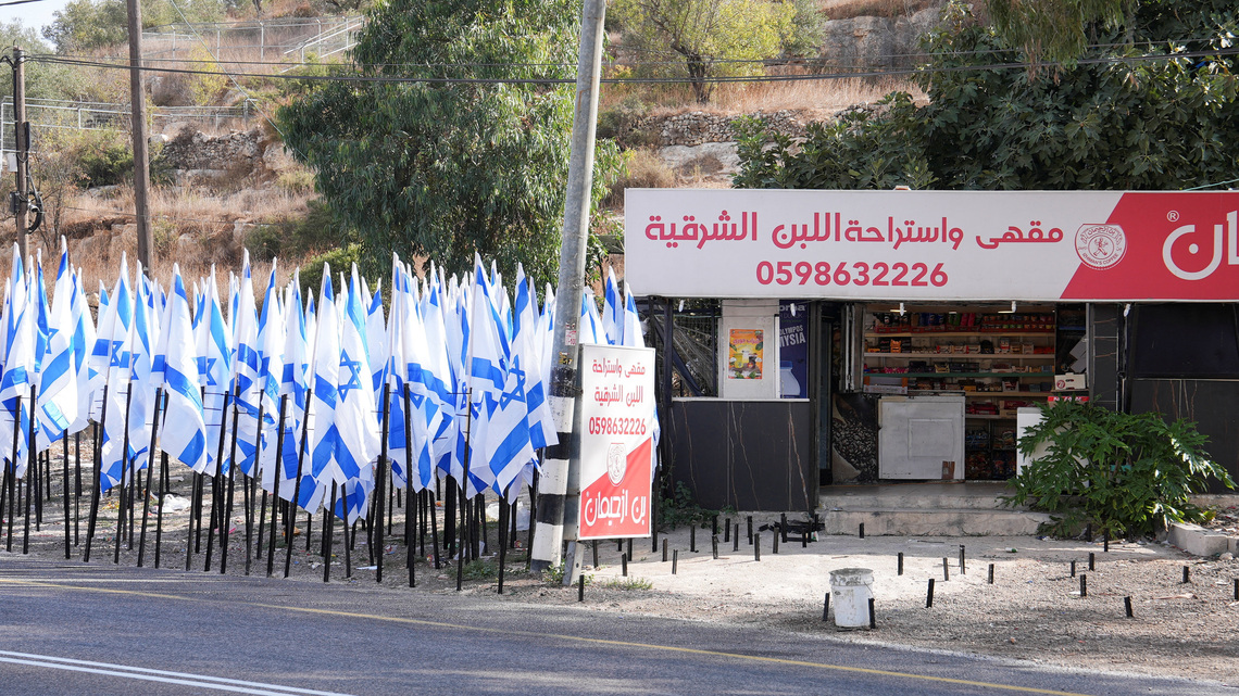 Israeli settlers flank Palestinian cafe with dozens of Israeli flags